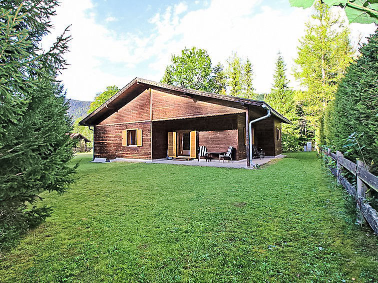 2-Zimmer-Chalet 65 m2. Komfortabel und mit viel Holz eingerichtet: Eingang. Wohn-/Esszimmer mit 1 Doppeldiwanbett (160 cm, Länge 200 cm), Essecke, Radio und Kachelofen. Ausgang zum Garten, zur Terras..