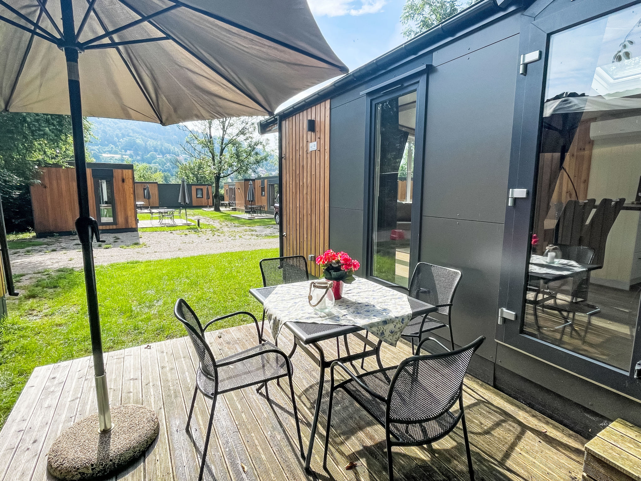 "Tiny Haus Josef", 3-kamers mobilhome 48 m2. Comfortabel ingericht: woon-/slaapkamer met 1 2-pers divanbed (160 cm, lengte 200 cm), zwedenkachel (alleen decoratie), Sat-TV en air-conditioning. Uitgang..