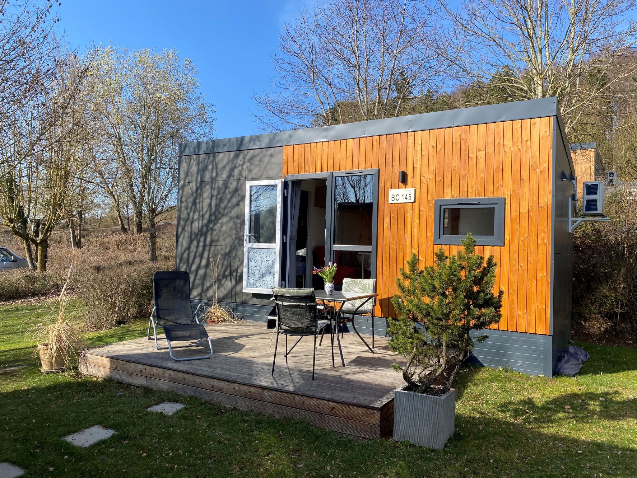 "Tiny Haus Waldsee Lodge", 2-kamers mobilhome 24 m2. Het objekt is geschikt voor 2 volwassenen + 2 kinderen. Gezellig ingericht: woon-/slaapkamer met 1 2-pers divanbed en Sat-TV. Uitgang naar het terr..