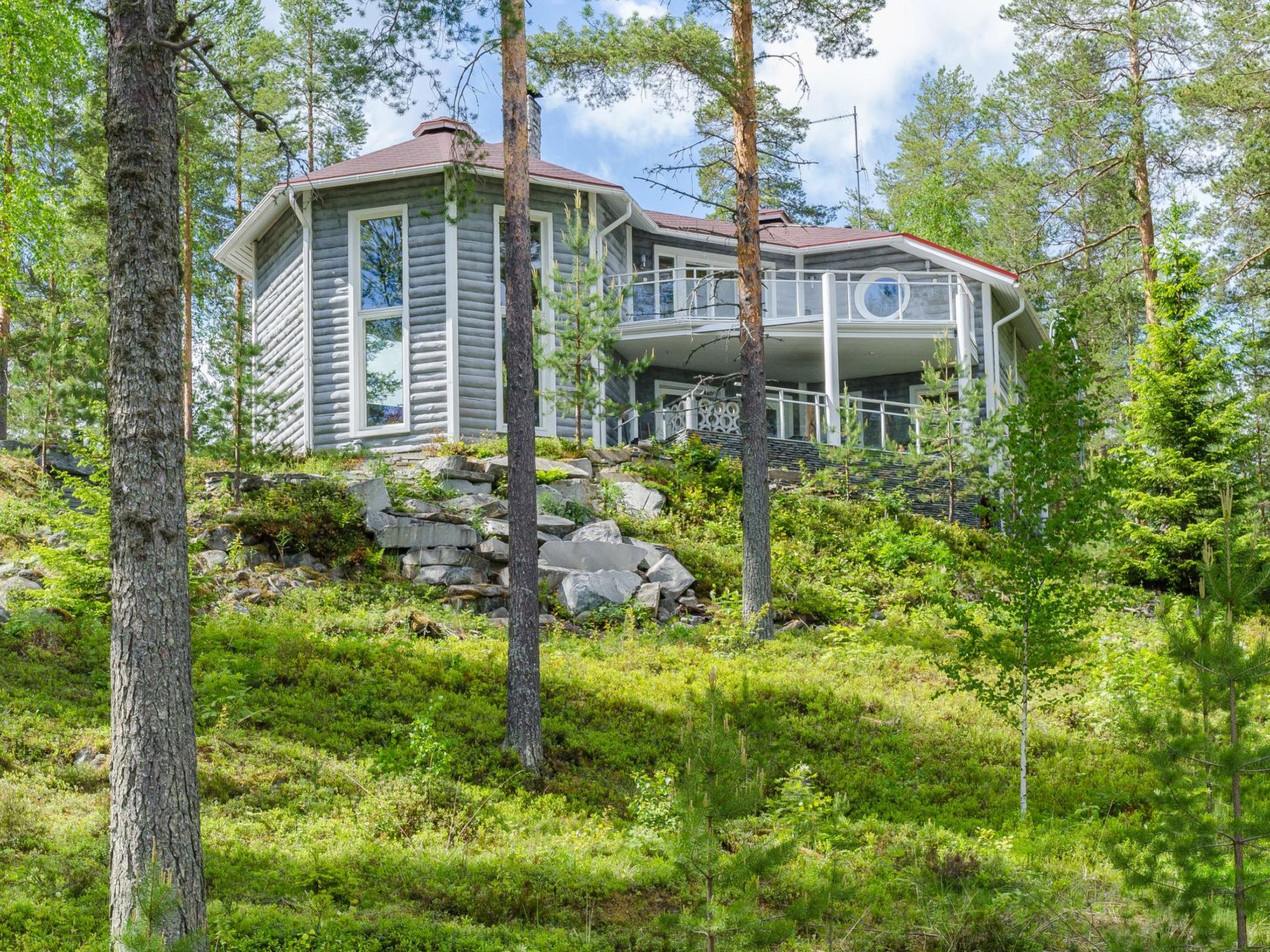 Built in solid concrete with a log cabin look, this house in the Loma-Koli holiday home area on the shores of Lake Pielinen stands out from the surrounding holiday homes thanks to its unique architect..