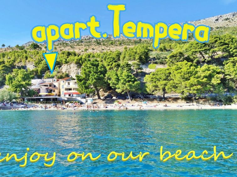 mit überdachter Terrasse und Balkon am Strand mit Meerblick
