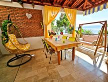 mit überdachter Terrasse und Balkon am Strand mit Meerblick