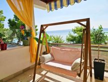 mit überdachter Terrasse und Balkon am Strand mit Meerblick