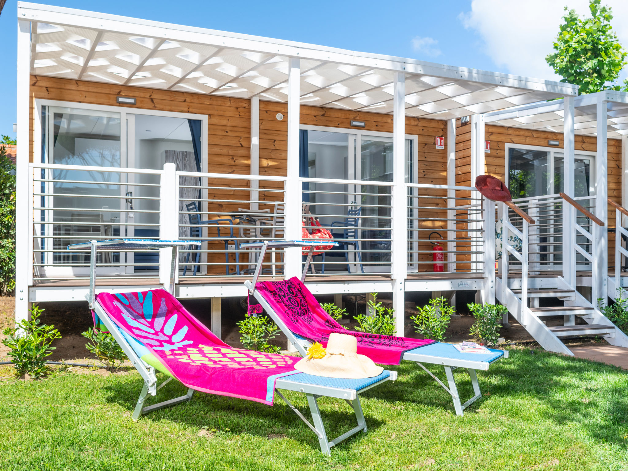 "Bungalow Charme", 2-kamers mobilhome 24 m2, op de begane grond. Eenvoudig en modern ingericht: woon-/eetkamer met 1 divanbed, kookhoek en TV (Flatscreen TV). Uitgang naar de tuin, naar de veranda. 1 ..