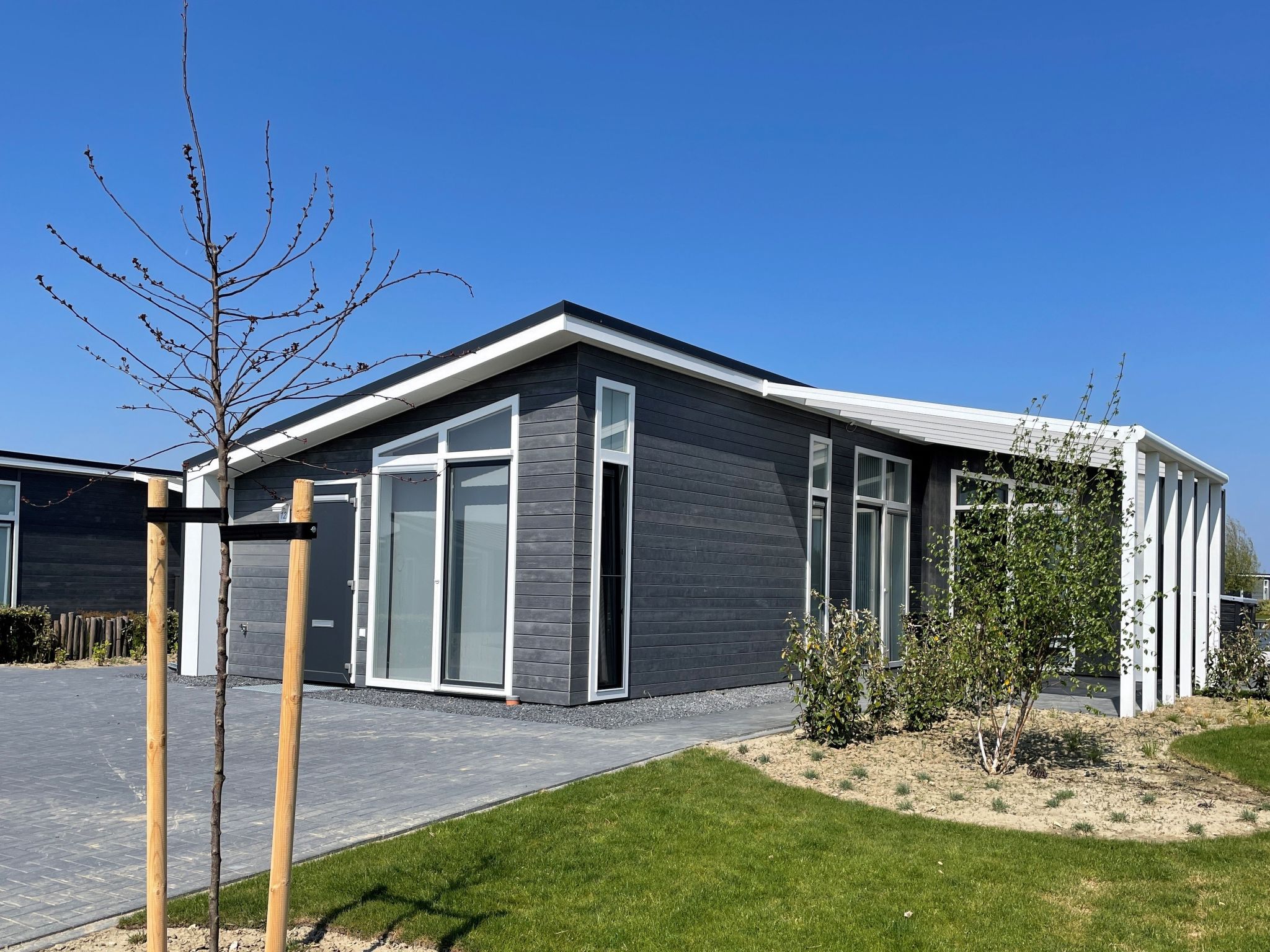 "Ruisweg 12", bungalow 4-kamers 93 m2. Comfortabel ingericht: hal met aparte WC. Woon-/eetkamer met eettafel en air-conditioning. Uitgang naar het terras. 1 2-pers. kamer met 2 bedden (80 cm, lengte 1..