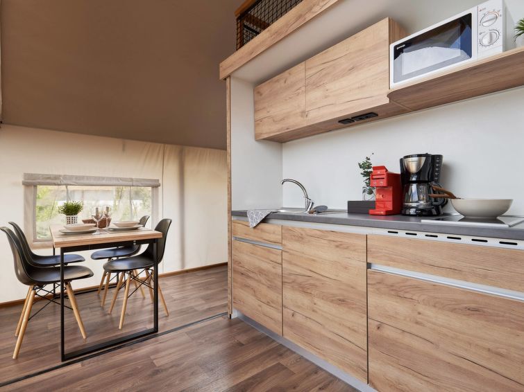 "Glampingtent 6", 1-kamer mobilhome. Doelmatig en gezellig ingericht: open woon-/eetkamer met eettafel en TV. Uitgang naar het terras. 2 open kamers met gordijn, elke kamer heeft 2 bedden. Open keuken..
