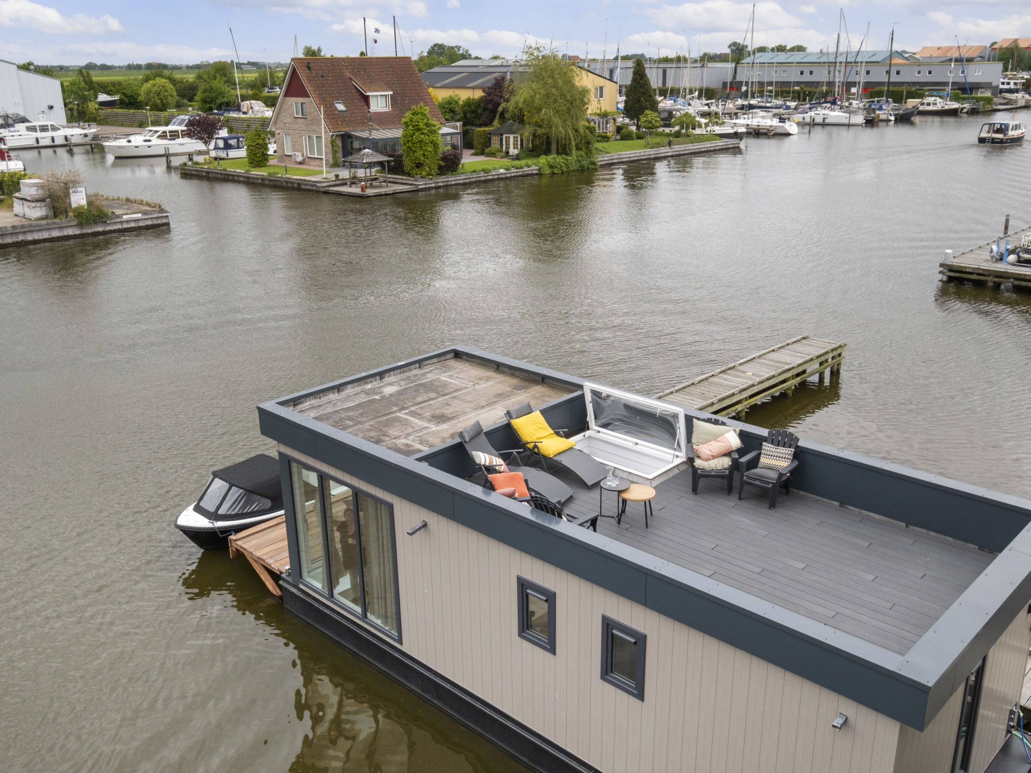 "Harboursuite 2 incl. Motorboot", 3-Zimmer-Haus 42 m2. Komfortabel eingerichtet: Wohnzimmer. Ausgang zum Balkon. 1 Zimmer mit 1 x 2 Etagenbetten. 1 Zimmer mit 1 Doppelbett. Offene Küche (4 Kochplatte..